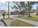 House exterior featuring a three-car garage and mature trees at 609 Salt Lake Dr, Tarpon Springs, FL 34689