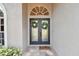 Double front doors with glass panels and wreaths at 609 Salt Lake Dr, Tarpon Springs, FL 34689
