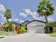 House exterior featuring a two-car garage and well-manicured landscaping at 8424 Bluevine Sky Dr, Land O Lakes, FL 34637