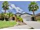 House exterior with palm trees and a two-car garage at 8424 Bluevine Sky Dr, Land O Lakes, FL 34637