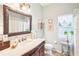 Elegant bathroom with dark wood vanity, marble countertop, and decorative mirror at 8831 Bel Meadow Way, Trinity, FL 34655