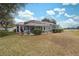 House's back with covered patio, pool, and lush landscaping at 9090 Alexandria Dr, Weeki Wachee, FL 34613