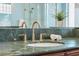 Bathroom sink with green marble countertop and gold faucet at 9090 Alexandria Dr, Weeki Wachee, FL 34613