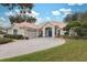 House exterior, showcasing a tile roof, landscaping, and a paved driveway at 9090 Alexandria Dr, Weeki Wachee, FL 34613