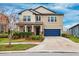 Two-story house with a blue garage door and landscaped front yard at 9173 Shadyside Ln, Land O Lakes, FL 34637