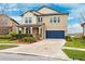 Two-story house with a blue garage door and neatly landscaped yard at 9173 Shadyside Ln, Land O Lakes, FL 34637