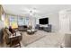 Spacious living room featuring a large sectional sofa, two armchairs, and a large flat-screen TV at 9173 Shadyside Ln, Land O Lakes, FL 34637