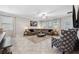 Open living room with sectional sofa, armchairs, and view into the kitchen area at 9173 Shadyside Ln, Land O Lakes, FL 34637