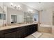 Elegant bathroom featuring double vanity, soaking tub, and walk-in shower at 9323 Bella Vita Cir, Land O Lakes, FL 34637