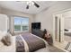Well-lit bedroom with a queen bed, TV, and access to another room at 9323 Bella Vita Cir, Land O Lakes, FL 34637