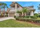 Two-story house with a balcony, two-car garage, and lush landscaping at 9323 Bella Vita Cir, Land O Lakes, FL 34637