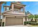 Two-story house with a balcony, two-car garage, and palm trees at 9323 Bella Vita Cir, Land O Lakes, FL 34637