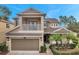Two-story home with balcony, two-car garage, and landscaping at 9323 Bella Vita Cir, Land O Lakes, FL 34637