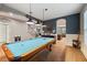 Game room featuring a pool table, hardwood floors, and an open concept to the kitchen at 9323 Bella Vita Cir, Land O Lakes, FL 34637