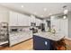 Modern kitchen with white cabinets, granite countertops, and a blue island at 9323 Bella Vita Cir, Land O Lakes, FL 34637