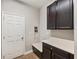 Laundry room with built-in cabinetry, a bench, and a door at 9323 Bella Vita Cir, Land O Lakes, FL 34637