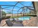 Screened pool and spa with lounge chairs under a covered patio at 9323 Bella Vita Cir, Land O Lakes, FL 34637