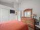 Serene bedroom with coral bedding and wood dresser at 13721 Mill Pl, Odessa, FL 33556
