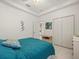 Spacious bedroom with teal bedding and a view of the kitchen at 13721 Mill Pl, Odessa, FL 33556