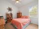 Cozy bedroom with coral bedding and wood furniture at 13721 Mill Pl, Odessa, FL 33556