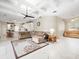 Spacious living room featuring a large sectional sofa, tile flooring, and a view of the kitchen at 13721 Mill Pl, Odessa, FL 33556