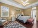 Large main bedroom with a king-size bed, dark wood floors, and an en-suite bathroom at 13721 Mill Pl, Odessa, FL 33556