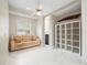 Bright sitting room with a beige sofa, built-in shelving, and tile flooring at 13721 Mill Pl, Odessa, FL 33556