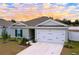 Newly built home with gray exterior, two-car garage, and landscaped yard at 14506 Whitewater Way, Brooksville, FL 34604