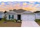 Newly built home with gray exterior, two-car garage, and landscaped yard at 14506 Whitewater Way, Brooksville, FL 34604