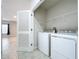 Bright laundry room with washer, dryer, and shelving at 14506 Whitewater Way, Brooksville, FL 34604