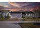 Two-story home with covered porch and landscaped yard at sunset at 18879 Sailors Delight Pass, Land O Lakes, FL 34638