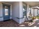 Inviting front porch with seating area, gray door, and brick pavers at 18879 Sailors Delight Pass, Land O Lakes, FL 34638
