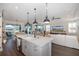 Modern kitchen with large island, stainless steel appliances, and view to living room at 18879 Sailors Delight Pass, Land O Lakes, FL 34638