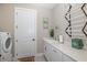 Bright laundry room includes a utility sink and additional storage at 18879 Sailors Delight Pass, Land O Lakes, FL 34638