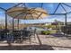 Outdoor dining area on a screened patio with lake views at 18879 Sailors Delight Pass, Land O Lakes, FL 34638