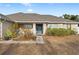 House exterior featuring a blue front door and well-maintained landscaping at 4372 Odin St, Spring Hill, FL 34608