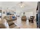 Bright living room featuring leather sofas, a ceiling fan, and large windows at 4372 Odin St, Spring Hill, FL 34608