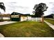 Rear view of house showcasing green garage and fenced backyard at 4649 Westerly Dr, New Port Richey, FL 34653