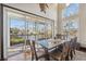 Bright dining room with glass table and chairs, access to a screened balcony overlooking the water at 5287 Tuna Ln, Weeki Wachee, FL 34607