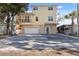 Two-story yellow house with balcony, garage, and spacious driveway at 5287 Tuna Ln, Weeki Wachee, FL 34607
