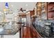 Modern kitchen with dark wood cabinets, granite countertops, and stainless steel appliances at 5287 Tuna Ln, Weeki Wachee, FL 34607