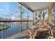 Relaxing screened balcony with wicker chairs and a table, overlooking the water at 5287 Tuna Ln, Weeki Wachee, FL 34607