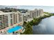 Aerial view showcasing condo building, pool, and waterfront location at 5915 Sea Ranch Dr # 501, Hudson, FL 34667