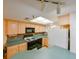 Efficient kitchen with light wood cabinets, teal countertops, and appliances at 5915 Sea Ranch Dr # 501, Hudson, FL 34667