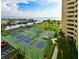 Aerial view of well-maintained tennis courts with waterfront views at 5915 Sea Ranch Dr # 501, Hudson, FL 34667