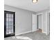 Bright bedroom with gray walls, new carpet, and a door leading to a private balcony at 5925 Seaside Dr, New Port Richey, FL 34652