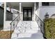 White house entrance with black double doors and wrought iron railings at 5925 Seaside Dr, New Port Richey, FL 34652
