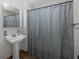 Bathroom with pedestal sink, shower, and gray curtain at 6166 Newmark St, Spring Hill, FL 34606