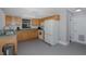 Simple kitchen with light wood cabinets and white appliances at 6166 Newmark St, Spring Hill, FL 34606