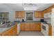 Kitchen with oak cabinets, white appliances, and track lighting at 6166 Newmark St, Spring Hill, FL 34606